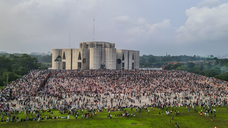 Thousands of people pictured outside parliament house in Dhaka following the resignation of Sheikh Hasina over the weekend