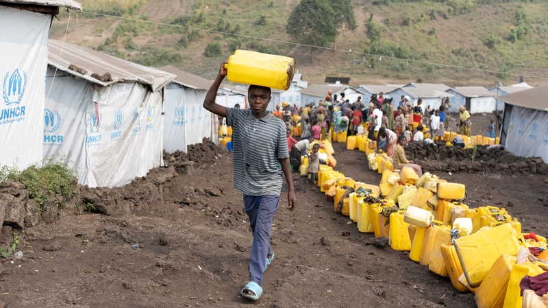 A boy who has recovered from mpox walks with a jerrycan at the Muja camp near Goma in DRC