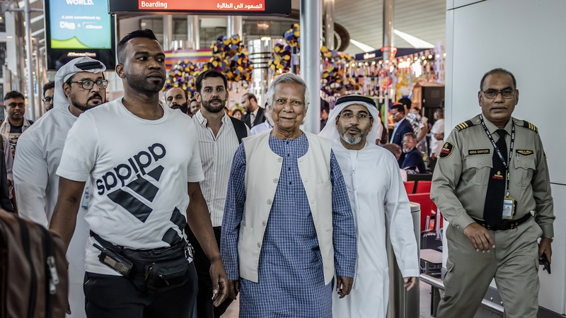 Muhammad Yunus (C) is escorted by Emirati security personnel as he walks at the Dubai International Airport before boarding his flight to Dhaka