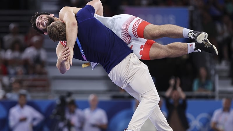 Denmark's Turpal Ali Alvievich Bisultanov and his coach celebate in fine wrestling tradition after winning in the 87kg Men's Greco-Roman Wrestling Final on Thursday