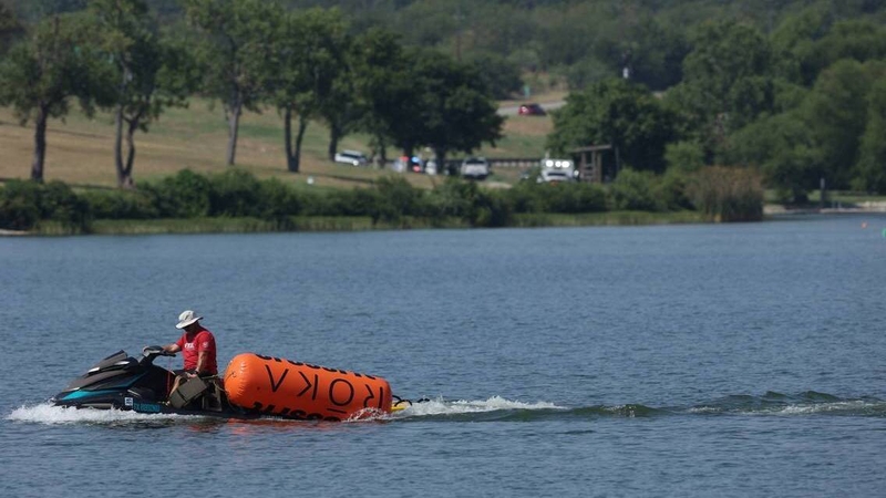 A jet ski pulls in buoys from the CrossFit Games at Marine Creek Lake in Fort Worth yesterday morning