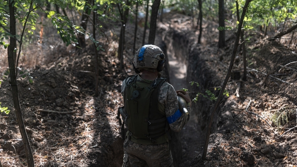 Ukrainian soldiers of the 'Da Vinci Wolves' battalion walk through a trench towards their mortar position in the direction of Pokrovsk on 31 July