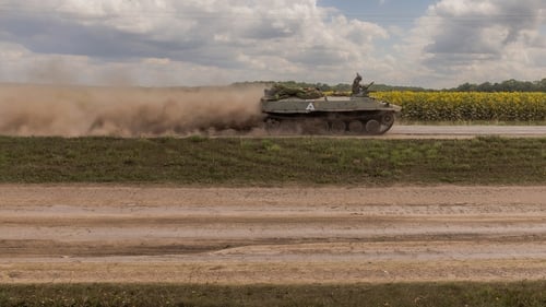Ukrainian troops are seen passing fields of sunflowers in the Sumy region, near the border with Russia