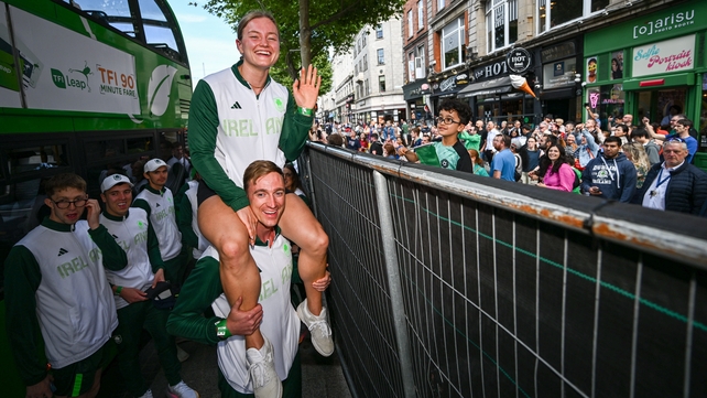 Mona McSharry is carried by swimming teammate Shane Ryan after departing a bus to the homecoming reception