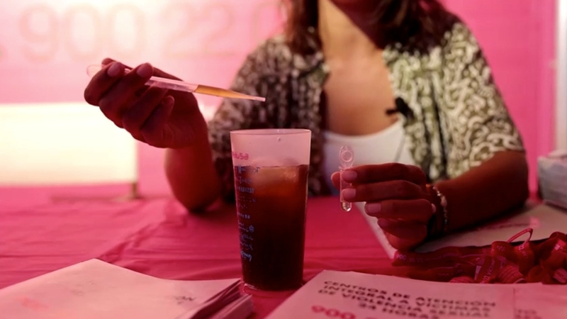 Samples are taken with droppers from attendees' drinks and inserted into a test tube with a chemical reagent