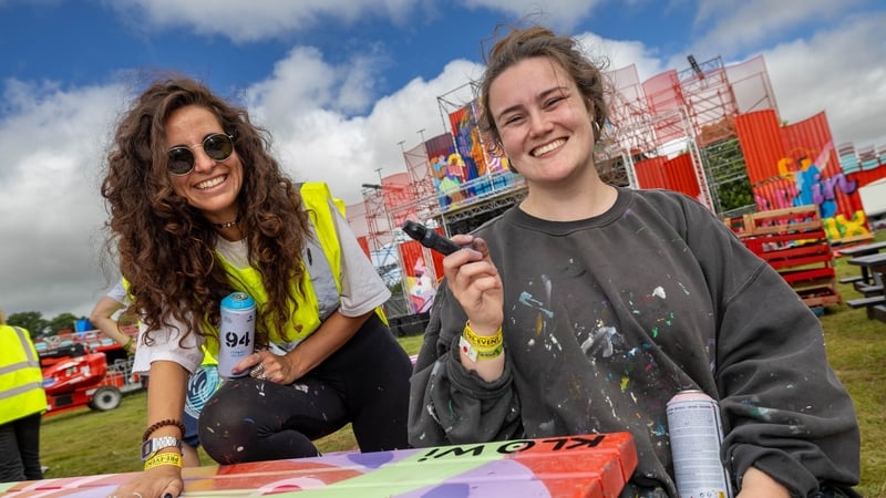Lara Lantero and Chloe Winders putting the finishing touches to tables they painted .Picture: Alf Harvey supplied from LHP for Electric Picnic 2024.