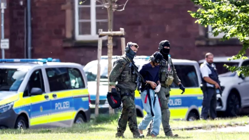 Police are seen escorting the Solingen stabbing suspect in Karlsruhe