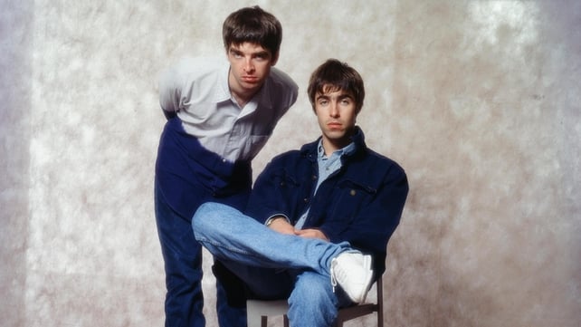 Noel Gallagher and Liam Gallagher at a photoshoot in a hotel in Tokyo, 1994. Photo by Koh Hasebe/Shinko Music/Getty Images.