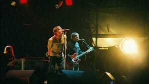 Liam and Noel Gallagher perform onstage in Finsbury Park, London, 2002. Photo by Pete Still/Redferns.