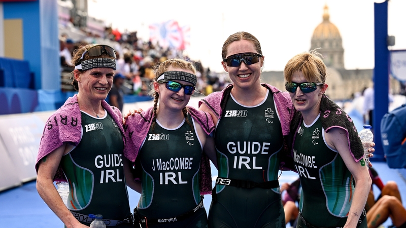 Guide Eimear Nicholls, Judith MacCombe, guide Catherine Sands and Chloe MacCombe pose for photographers after the conclusion of the triathlon at the Pont Alexandre III