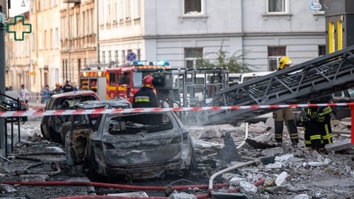 Rescuers work amid rubble and burnt out cars at the site of a Russian missile strike in Lviv