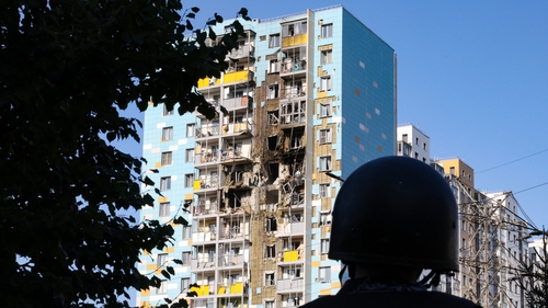 A member of Moscow's security forces surveying the damage caused to an apartment block by a Ukrainian drone attack