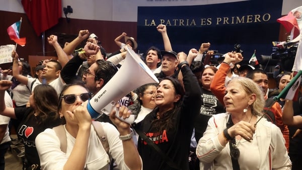 The reform was approved after politicians were forced to move to a new venue due to protests