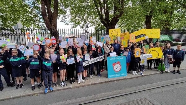 Daltaí, tuismitheoirí agus múinteoirí gaelscoile ag éileamh Gaelcholáiste.