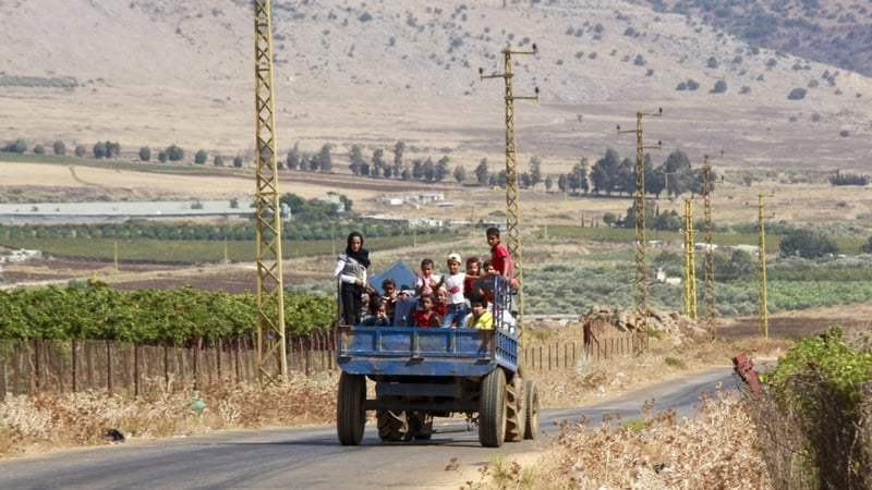 Syrian refugees leave the southern Lebanese village of Wazzani after the Israeli army dropped leaflets calling for them to evacuate