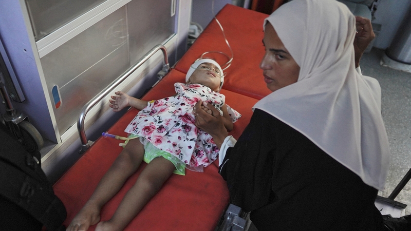 Cailín óg a bhfuil ailse uirthi á tabhairt as Gaza go dtí an Iordáin in éineacht lena máthair, 15 Lúnasa 2024