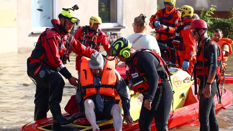 Residents pictured being evacuated by emergency workers after a river flooded a town in southwestern Poland