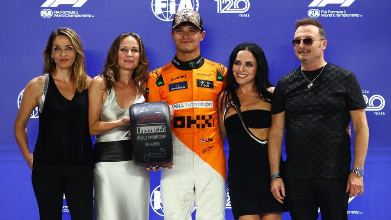 Lando Norris is presented with the Pirelli pole position award by The Corrs