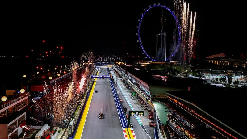 Lando Norris takes the chequered flag as the fireworks go off in Singapore