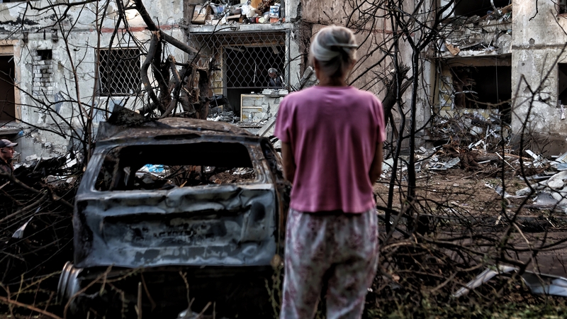 A woman looks at a residential building that was damaged in the Shevchenkivskyi district in Ukraine over the weekend