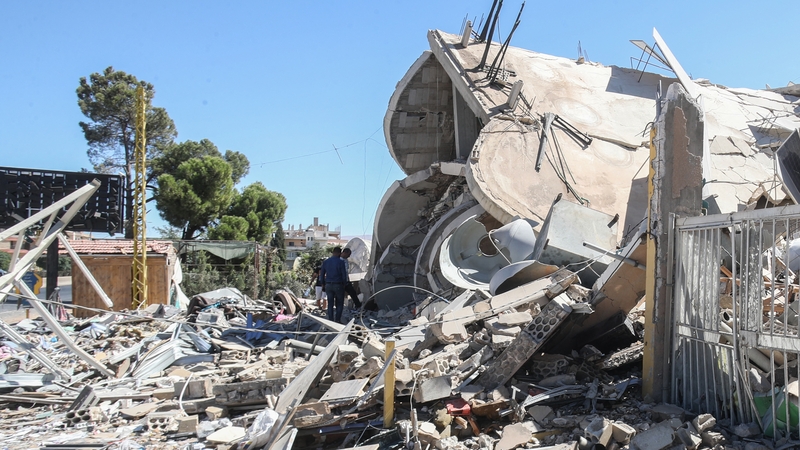People check the destruction in a neighbourhood targeted by Israeli airstrikes in the eastern Lebanese village of Douris