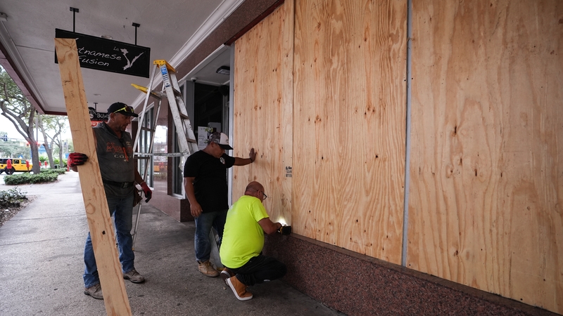 Workers board up a business in Florida ahead of Hurricane Milton