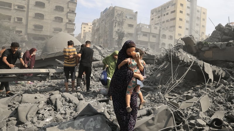 Palestinians evacuate the area following an Israeli airstrike on the Sousi mosque in Gaza City on 9 October