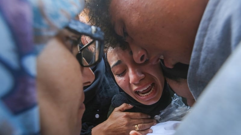 Family members mourn a young child killed in a Israeli strike in Deir al-Balah