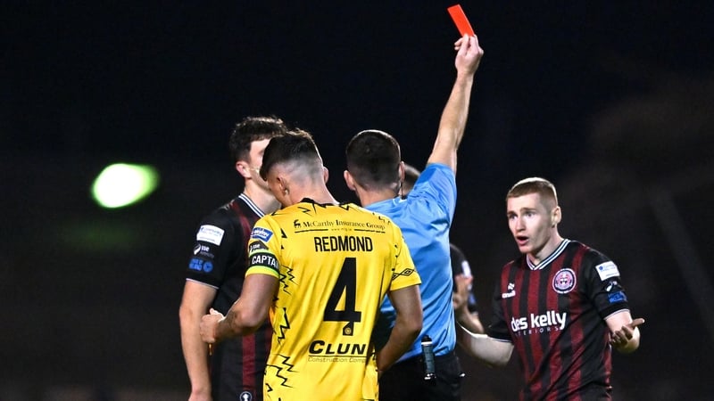 Referee Rob Hennessy shows a red card to Ross Tierney of Bohemians