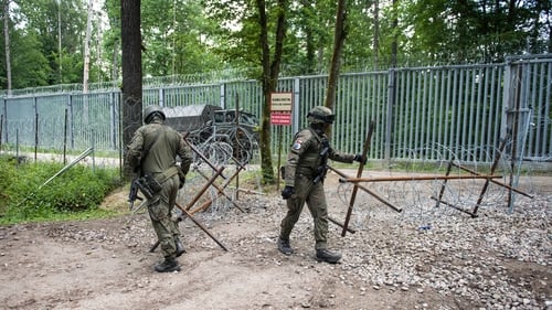 Polish soldiers patrolling the border with Belarus along the border fence in the Bialowieza forest.