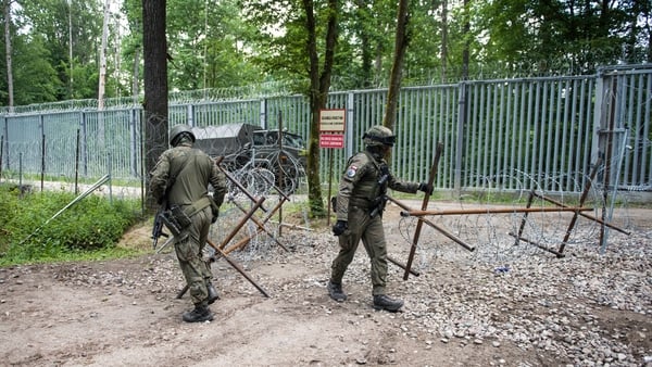 Polish soldiers patrolling the border with Belarus along the border fence in the Bialowieza forest.