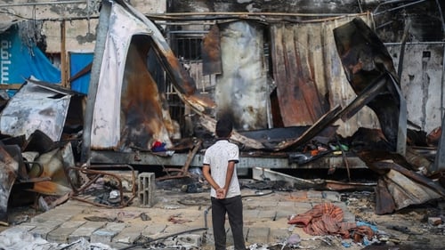 A boy looks at shelters destroyed in an Israeli airstrike which hit the courtyard of Al-Aqsa Martyrs Hospital in central Gaza this week
