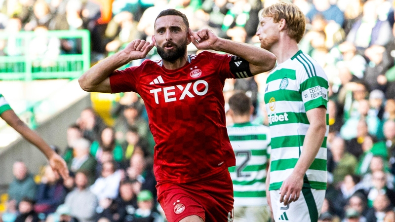 Graeme Shinnie celebrates his leveller as Ireland's Liam Scales reacts