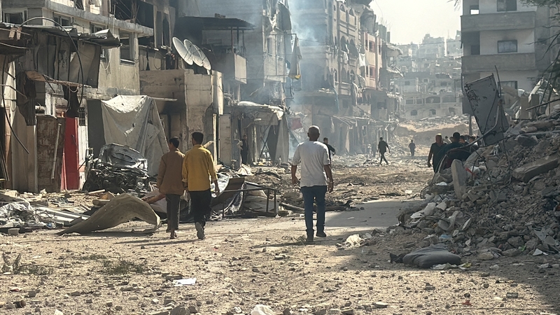 Palestinians walk past damaged and destroyed buildings in Beit Lahia the northern Gaza Strip