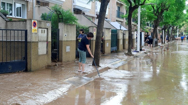 A resident cleans her house in a street covered in mud following flood in Picanya, near Valencia, in Spain. Photo: Jose Jordan/AFP