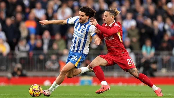 Ferdi Kadioglu of Brighton & Hove Albion runs holds off Kostas Tsimikas