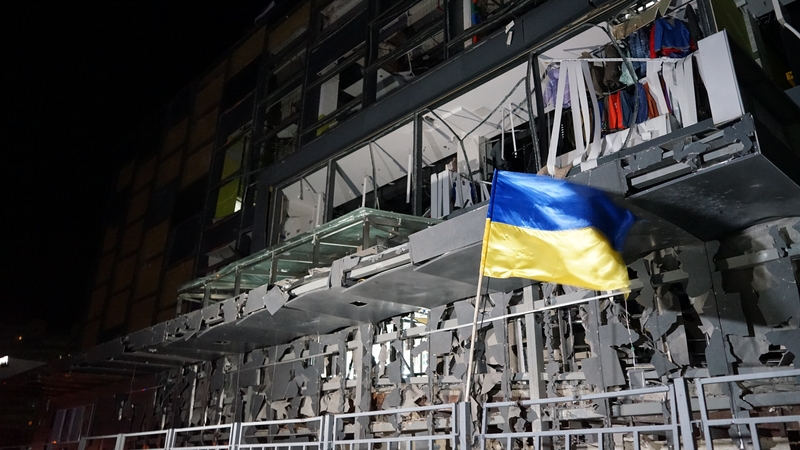 A Ukrainian flag flies outside a damaged shopping centre in Kharkiv
