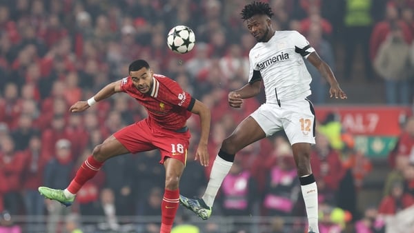 Liverpool's Cody Gakpo (L) rises with Edmond Tapsoba of Bayer 04 Leverkusen