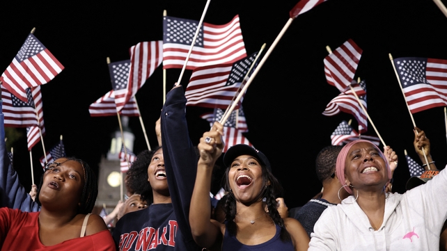 Supporters wave US flags during an election night event for Kamala Harris earlier in the night