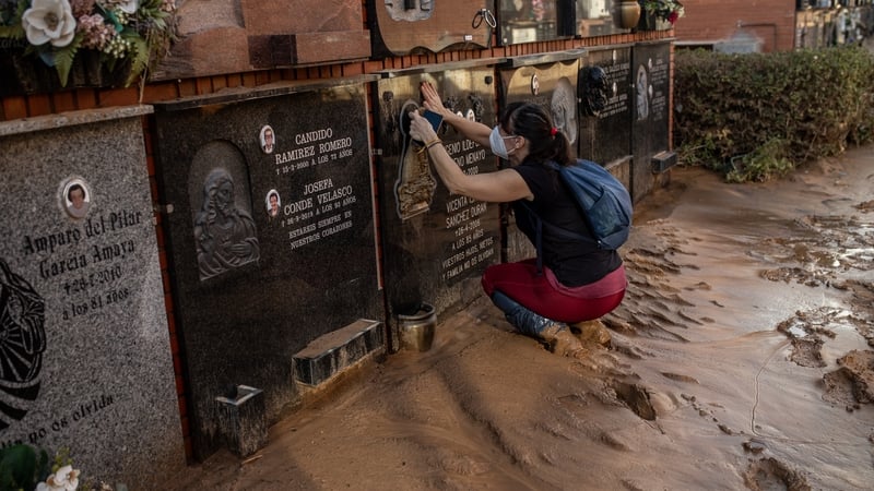 A woman at her grandparents' grave in Alfafar cemetery, Valencia