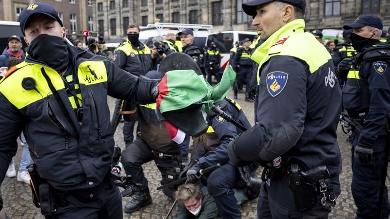 Police officers clash with pro-Palestine protesters during a demonstration on Dam Square