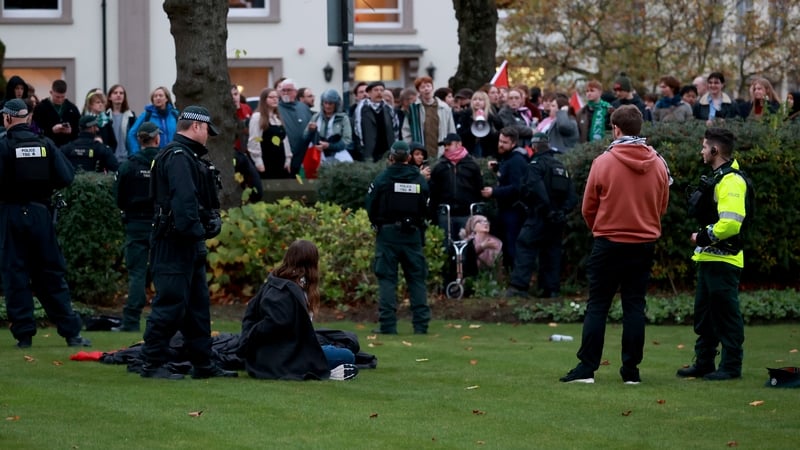 Police detain protesters who gathered outside Queen's University Belfast, during a visit from Hillary Clinton