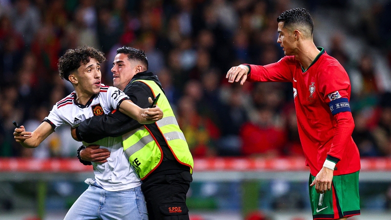 A pitch invader tries to get through to Cristiano Ronaldo