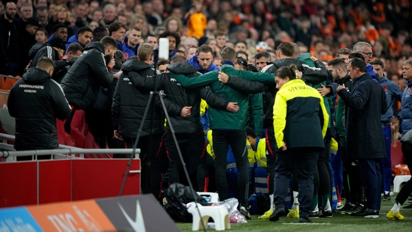 Staff members of Hungary huddle together during the medical emergency treatment of Adam Szalai