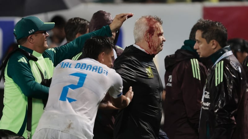 A bloodied Javier Aguirre leaves the pitch at General Francisco Morazan Stadium in San Pedro Sula