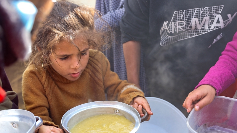 A Palestinian girl gets a meal of lentils from a volunteer food distribution point in Gaza city