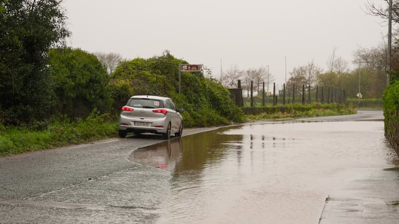 A car is driven past a flooded road at Passage West in Co Cork as Storm Bert battered the west coast of Ireland