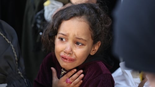 A Palestinian girl cries as victims of an Israeli air strike are brought to Al-Ahli Arab in Gaza city