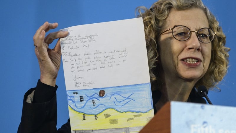 UN Environment Programme chief Inger Andersen holds up a letter from a child as she speaks during the opening session