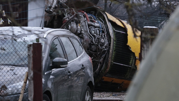 The wreckage of the cargo plane is seen by the house it crashed into near Vilnius Airport